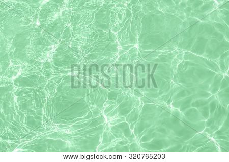 Closeup Of Calm Clear Water Surface With Water Splashes In Trendy Mint Color. Swimming Pool Water Te