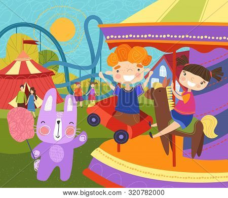 Two Young Children Having Fun At The Fairground Riding On A Colorful Carousel Or Merry-go-round Watc