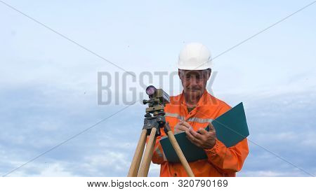 Skilled Surveyor Fixes Dumpy Level On Brown Wooden Tripod