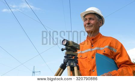 Experienced Survey Specialist Stands Near Dumpy Level