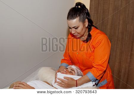 Close-up Female Hands Lie On A White Terry Towel. Preparation For Spa Treatments.