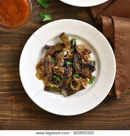 Fried Beef Liver With Onion On Plate Over Wooden Background. Pieces Cooked Liver (offal) From Beef. 