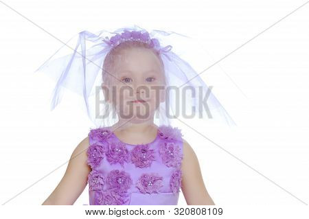 A Sweet Little Round-faced Girl In A Smart Purple Dress. With A Veil Covering His Face.she Makes A C