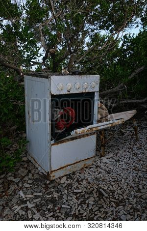 Old Rusty Oven In The Outside With A Red Lantern Inside Of It