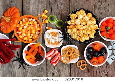 Halloween Candy Buffet Table Scene Over A Rustic Wood Background. Assortment Of Sweet, Spooky Treats