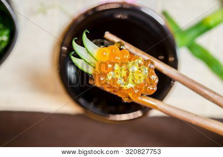 Wooden Chopsticks Tongs Gunkan Maki Sushi With Salmon Caviar (ikura) And Cucumber In Japanese Food R