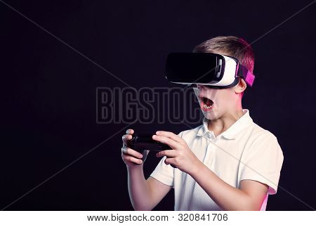 Side View Of Excited Kid In White T-shirt And Virtual Reality Headset Standing Bending Forward Playi
