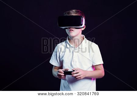 Excited Kid In White T-shirt And Virtual Reality Headset Standing Bending Forward Playing With Joyst