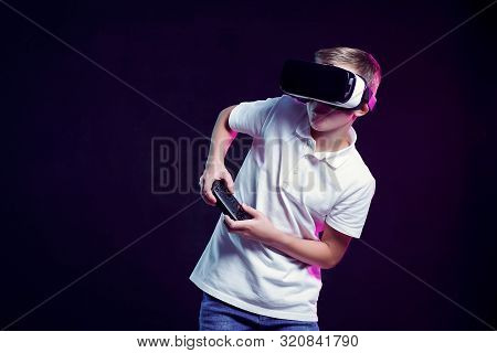 Excited Kid In White T-shirt And Virtual Reality Headset Standing Bending Forward Playing With Joyst