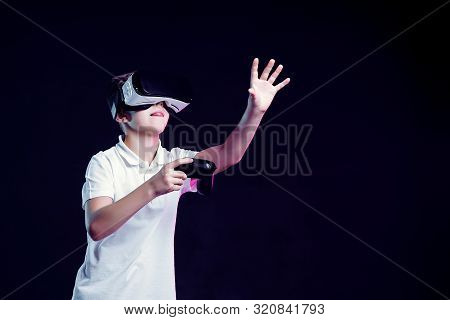 Side View Of Excited Kid In White T-shirt And Virtual Reality Headset Standing Bending Forward Playi