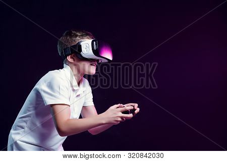 Side View Of Excited Kid In White T-shirt And Virtual Reality Headset Standing Bending Forward Playi