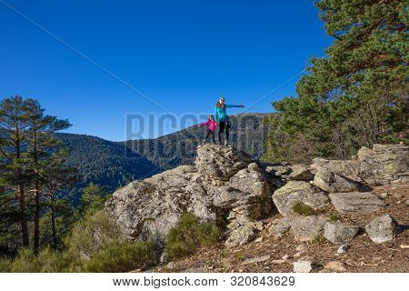 Happy Family (woman And Five Years Old Girl) Posing On The Top Of Rock In Mountain Of Fuenfria Valle