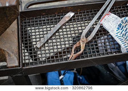 Metal Blacksmith Equipment On A Black Trellis.