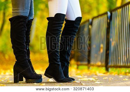 Two Unrecognizable Women Wearing Long Black Heeled Knee High Boots And Jeans. Autumn Fashion, Warm F