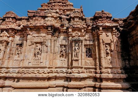 Gods And Heroes On Facade Of The Hindu Temple In India. Architecture Of 7th Century With Carved Wall