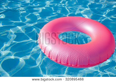 floating ring on blue water swimpool with waves reflecting in the summer sun