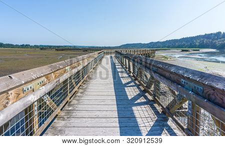 A View Of The Mud Flats And Boardwalk At The Nisqually Wetlands Near Olympia, Washington.