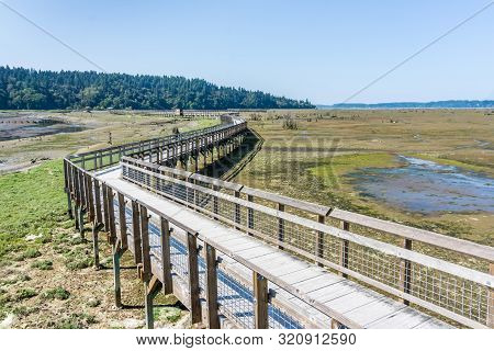 A View Of The Mud Flats And Boardwalk At The Nisqually Wetlands Near Olympia, Washington.