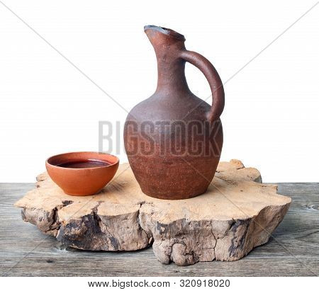 A Traditional Georgian Wine Jug And Clay Cups Filled With A Red Wine On The Wooden Table, Isolated B