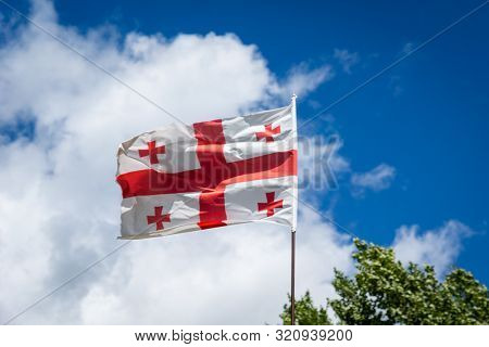 Georgian Flag Waving Against  Blue Sky - Flag Of Georgia, The Country Known Until 1995 As The Republ