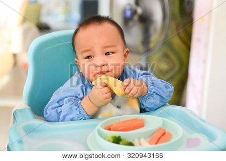 Asian Baby Boy 6 Months Old Eating With Baby Led Weaning (blw) Method, Self-feeding