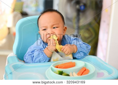 Asian Baby Boy 6 Months Old Eating With Baby Led Weaning (blw) Method, Self-feeding