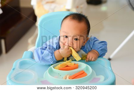 Asian Baby Boy 6 Months Old Eating With Baby Led Weaning (blw) Method, Self-feeding