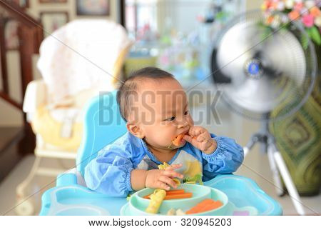 Asian Baby Boy 6 Months Old Eating With Baby Led Weaning (blw) Method, Self-feeding