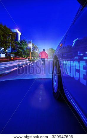 Police Sedan car speeding in the night through traffic lights, chasing a thief motion blur, Gaborone, Botswana,