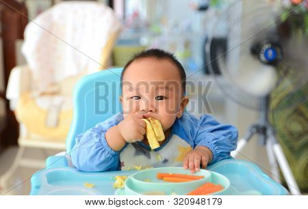 Asian Baby Boy 6 Months Old Eating With Baby Led Weaning (blw) Method, Self-feeding