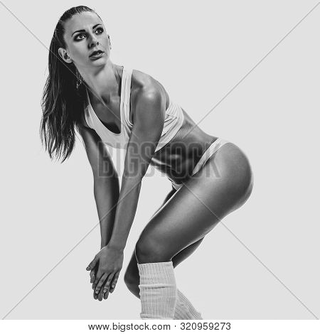 Athletic Sporty Woman Getting Ready To Training And Doing Stretching Exrcises, Black And White Image