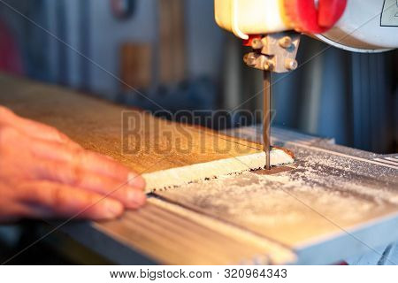 A Craftsman Cutting A Plank Of Wood With Bandsaw. Processing Wood In The Home Workshop. Board Making