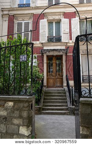 Paris / France - 06 26 2019: Picturesque Facade Of Traditional European Building With Red Brick Wall