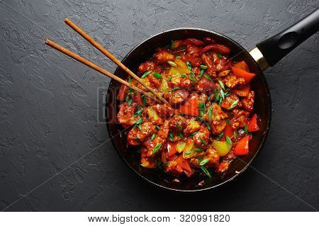 Chicken Manchurian In Pan At Black Concrete Background. Chicken Manchurian Is Indian Chinese Cuisine