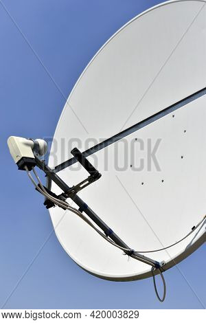 White Satellite Dish On Blue Sky Background