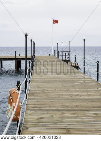 Deserted Pontoon With Orange Life Buoy And National Flag Of Turkey. Empty Hotels And Guesthouses Bec