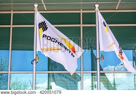Samara, Russia - May 8, 2021: Flags With Emblem Of Oil Company Rosneft Against Office Building. Rosn
