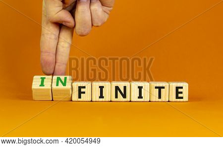 Finite Or Infinite Symbol. Businessman Turns Wooden Cubes And Changes The Word 'finite' To 'infinite