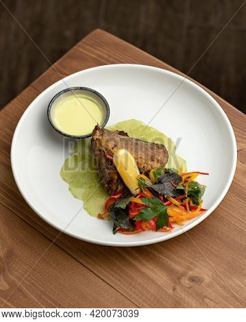 Plate Of Delicious Food On Wooden Table. Fried White Sea Or River Fish With Greens And Vegetables. N