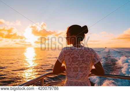Cruise ship vacation woman watching sunset boat deck on summer travel. Silhouette of tourist relaxing on outdoor balcony of boat ferry.