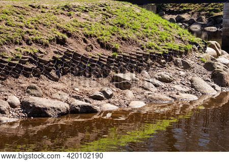 Flexible Rubber Geogrid To Reinforce The Shoreline On A Crumbling River Bank. Preservation Of Grass 