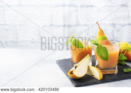 Natural Pear Juice In A Glass Cup. Juicy Ripe Conferences Pears And Mint Leaves. Copy Space Slate St