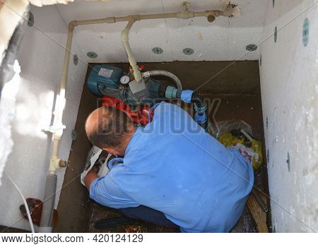 Kyiv, Ukraine - April,23, 2021: Installation Of A Water Pipe Station In A Borehole. A Man Is Install