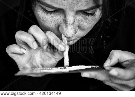 Drug Addict Sniffing And Snorting Cocaine,speed, Heroin Or Other Drug With Money Rolled Up On Mirror