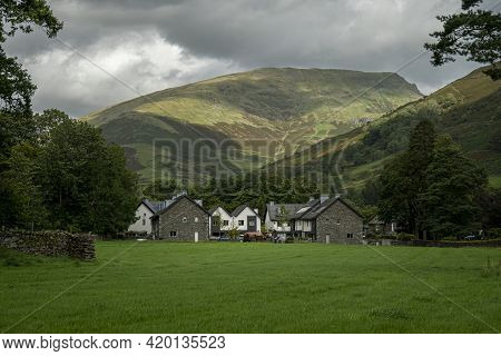 View Of Grasmere Village With Mountains In The Background, In The Lake District, Cumbria, Uk