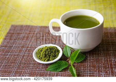Japanese Matcha Green Tea Is Poured Into A White Mug And On A White Saucer In Powder. Tea Set On A T