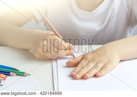 Focused Preschooler Little Boy 5-6 Years Painstakingly Draws Drawing By Pencil. Doing Homework, Draw