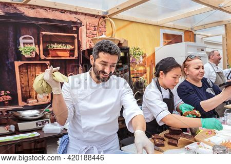 Moscow, Russia, July 13, 2019: An Italian Chef In Uniform Fills A Cream Cone With Cannoli Siciliani 