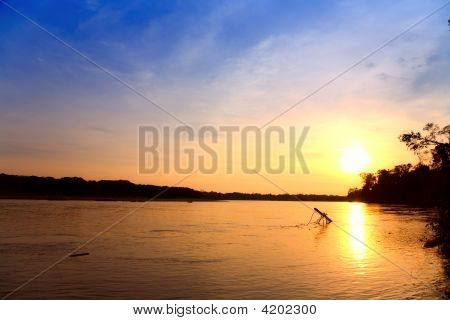 Auringonlasku joen rannalla