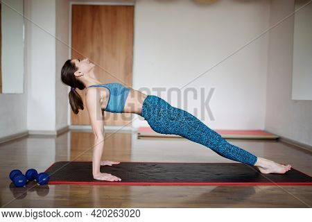 Athletic Woman Performs Reverse Plank Exercise In Gym